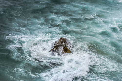 Rough sea swirling around a rock. Poster Print by Loop Images Ltd. (17 x 11)