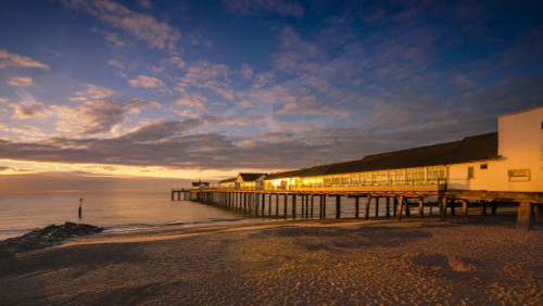 Southwold pier reflecting the early morning sun. Poster Print by Loop Images Ltd. (20 x 11)