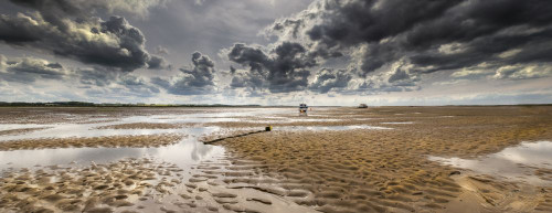 A single boat sitting on the sand at low tide at Morston in Norfolk. Poster Print by Loop Images Ltd. (23 x 8)