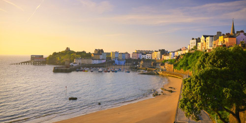 Sandy beach leading to the harbour in the seaside town of Tenby. Poster Print by Loop Images Ltd. (20 x 10)