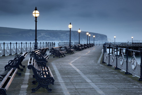 Benches under lamps along Swanage pier at twilight. Poster Print by Loop Images Ltd. (17 x 11)