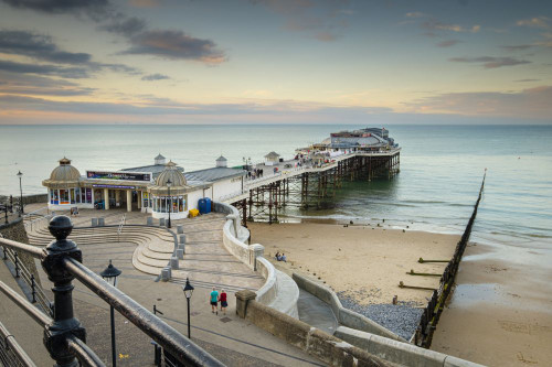 People start to arrive for the evening show in the pavilion at Cromer pier. Poster Print by Loop Images Ltd. (20 x 13)