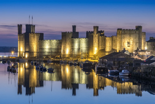 Caernarfon Castle and the River Seiont at night. Poster Print by Loop Images Ltd. (18 x 12)