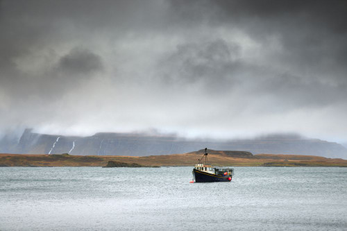 Fishing boat under stormy skies on the Isle of Mull. Poster Print by Loop Images Ltd. (20 x 13)