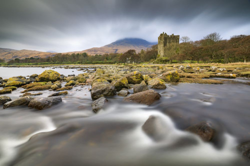 A stream at Loch Buie with Moy Castle in the distance. Poster Print by Loop Images Ltd. (20 x 13)