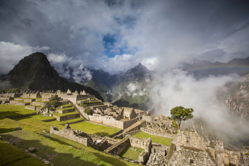 Rainbow emerges from the clouds over Machu Picchu; Peru Poster Print by Michael Melford (17 x 11)