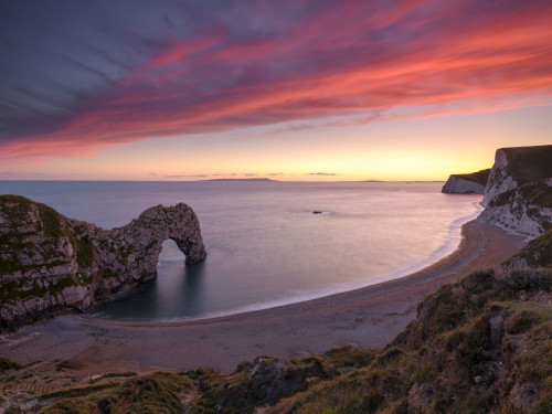 Sunset at the natural rock arch of Durdle Door. Poster Print by Loop Images Ltd. (18 x 14)