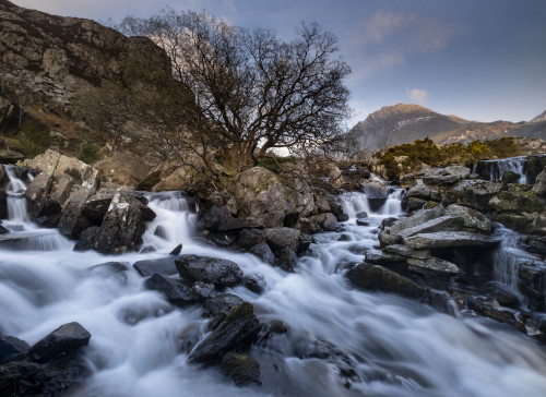 The top of Ogwen Falls and peak of Tryfan in the Ogwen Valley in Snowdonia. Poster Print by Loop Images Ltd. (18 x 13)