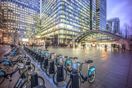 Canary Wharf tube station and Boris bikes. Poster Print by Loop Images Ltd. (19 x 13)