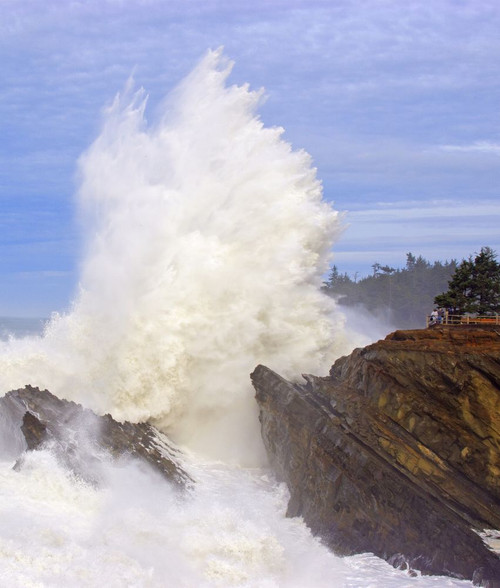 Powerful wave breaking against the rocks at Shore Acres State Park as tourists stand at a lookout point watching the intense splash, Oregon coast; Oregon, United States of America Poster Print by Craig Tuttle (14 x 16)