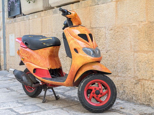 Croatia-Hvar. Bright orange vespa bike in the town of Hvar.
