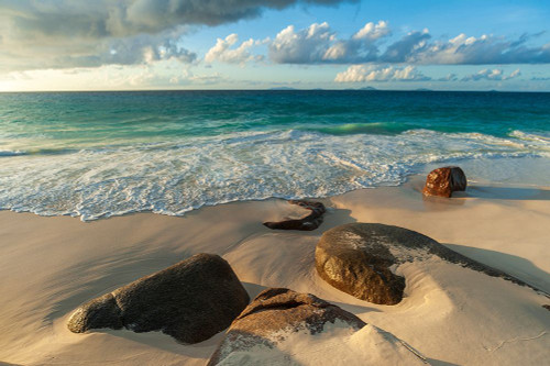 Surf surging towards boulders buried in sand on a tropical beach Anse Victorin Beach-Seychelles Poster Print - Sergio Pitamitz