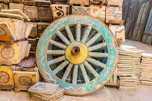 Old Cairo-Cairo-Egypt Wooden cart wheel and floor tiles in an alley in Cairo Poster Print - Emily M. Wilson