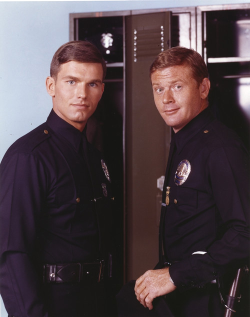 Adam-12 Posed in Police Uniform Looking at the Camera Near the Shelf in a Portrait Photo Print - Item # VARCEL680764
