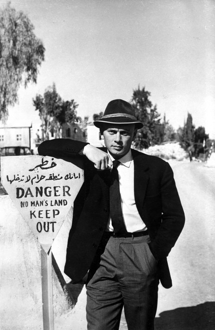 Yul Brynner leaning on a sign Photo Print - Item # VARCEL683545