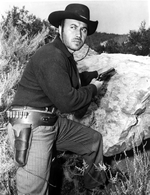 A Michael Ansara holding a gun and wearing a cowboy costume Photo Print - Item # VARCEL684105