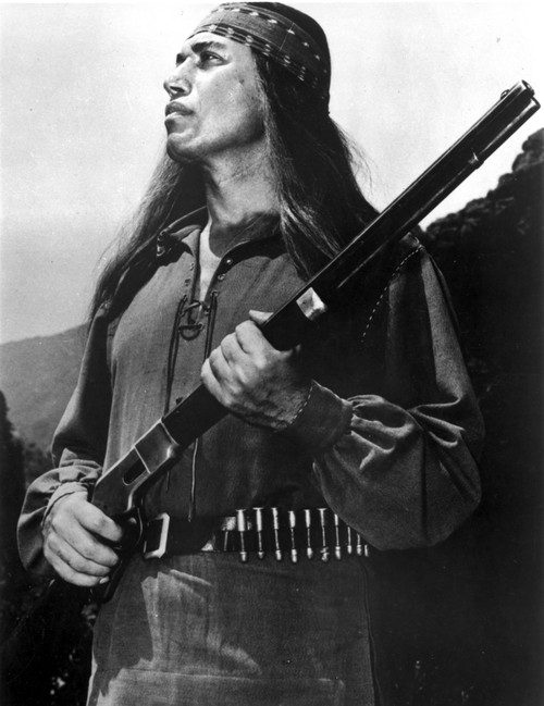Michael Ansara wearing a Native American costume and holding a rifle Photo Print - Item # VARCEL684106
