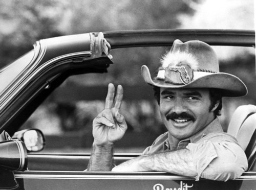 Film still of Burt Reynolds doing a peace sign in a car Photo Print - Item # VARCEL684190