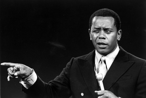 Flip Wilson on stage with a microphone pointing Photo Print - Item # VARCEL684901