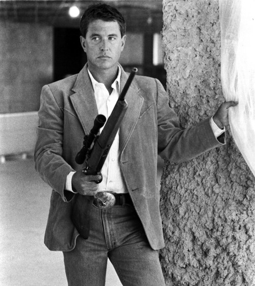 Film still of Tom Berenger wearing a suit and carrying a gun Photo Print - Item # VARCEL684922
