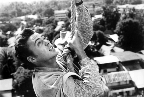 Robert Downey Jr climbing a rope in Air America Photo Print - Item # VARCEL685068