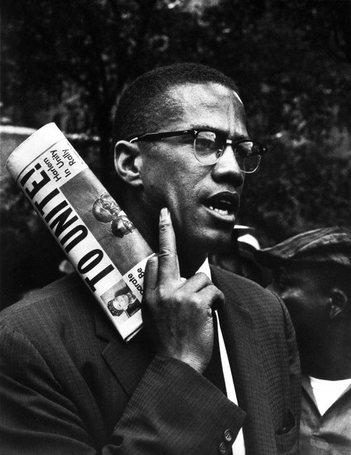 Malcolm X holding a newspaper Photo Print - Item # VARCEL685239