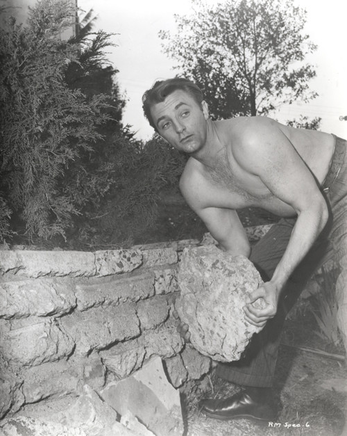 Film still featuring Robert Mitchum lifting a stone Photo Print - Item # VARCEL686102