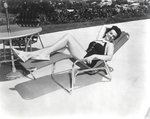 Jane Russell Seated on a Reclining Chair in Black One Piece Swimsuit Photo Print - Item # VARCEL687446