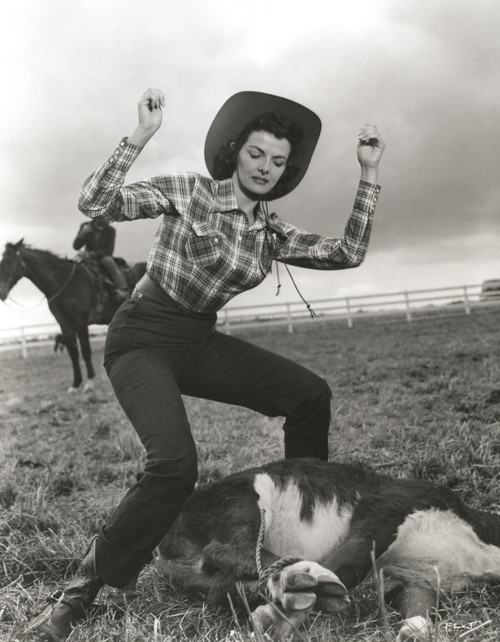 Jane Russell Posed in Checkered Tight Long Sleeve Collar Shirt and High Waist Linen Pants with Cowboy Hat while Hands Raised Up and Feet Apart Photo Print - Item # VARCEL687563