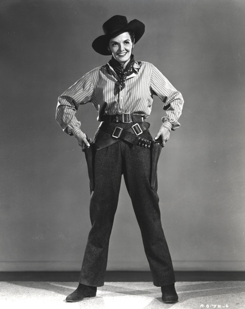 Jane Russell Posed in Long Sleeve Collar Shirt and Black Neckerchief with Cowboy Hat while Both Hands on the Side Holding a Gun Handle Photo Print - Item # VARCEL687556