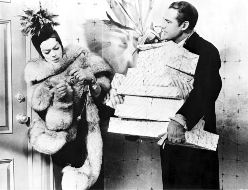 Rosalind Russell in Fur Coat with Man Carrying Presents Photo Print - Item # VARCEL687632