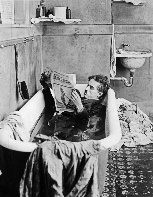A film still of Charlie Chaplin reading a newspaper in a bathtub Photo Print - Item # VARCEL688062