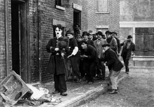 Charlie Chaplin Walking on Street with Men Following Him Photo Print - Item # VARCEL688071