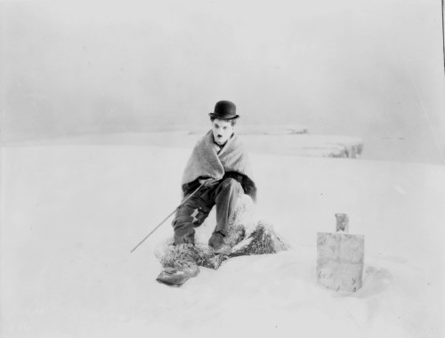 A film still of Charlie Chaplin sitting in the snow Photo Print - Item # VARCEL688141