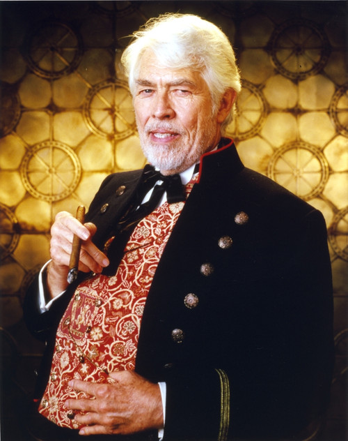 James Coburn Portrait in Black Velvet Suit and Brown Shiny Silk Shirt with Black Bow Tie with Right Hand Holding a Small Smoking Pipe Photo Print - Item # VARCEL688476