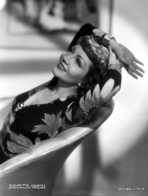 Claudette Colbert sitting in Floral Dress with Two Hands on Head Photo Print - Item # VARCEL688503