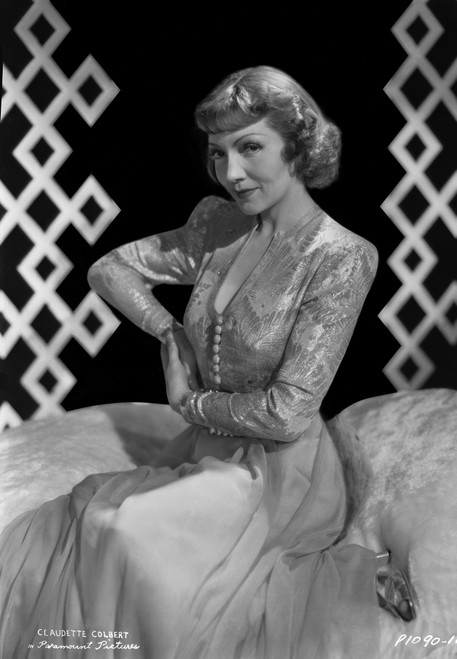 Claudette Colbert sitting on Bed, wearing Floral Dress Photo Print - Item # VARCEL688509