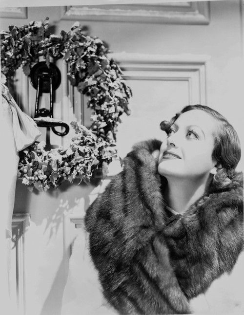 Joan Crawford wearing a fur scarf beside a wreath Photo Print - Item # VARCEL688741
