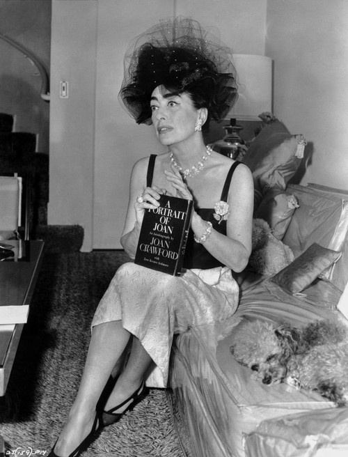 Joan Crawford sitting on the Sofa and Holding a Book in Classic Photo Print - Item # VARCEL688752