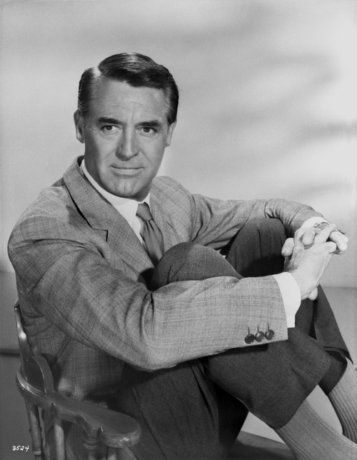 Cary Grant in a blazer and tie sitting down with arms around legs - Photo Print - Item # VARCEL696062