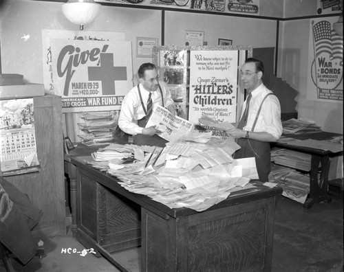Two men with a pile of newspapers Photo Print - Item # VARCEL696096