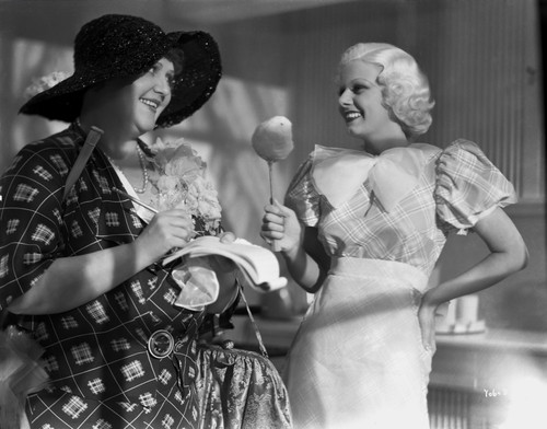Jean Harlow Scene from a Film standing in Tartan Short Sleeve Linen Dress with Right Hand Holding a Big Spoon Photo Print - Item # VARCEL697037