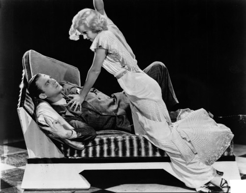 Jean Harlow Scene from a Film Knelt on the Couch in White Ruffled Short Sleeve Silk Dress with Frilled Skirt Photo Print - Item # VARCEL697143