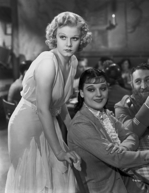 Jean Harlow Scene from a Film standing while Leaning Forward in White Silk Dress Photo Print - Item # VARCEL697251