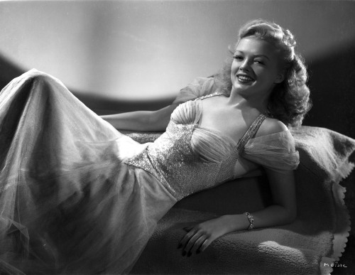 Myrna Dell Laying on Couch wearing Gown in Black and White Photo Print - Item # VARCEL697410