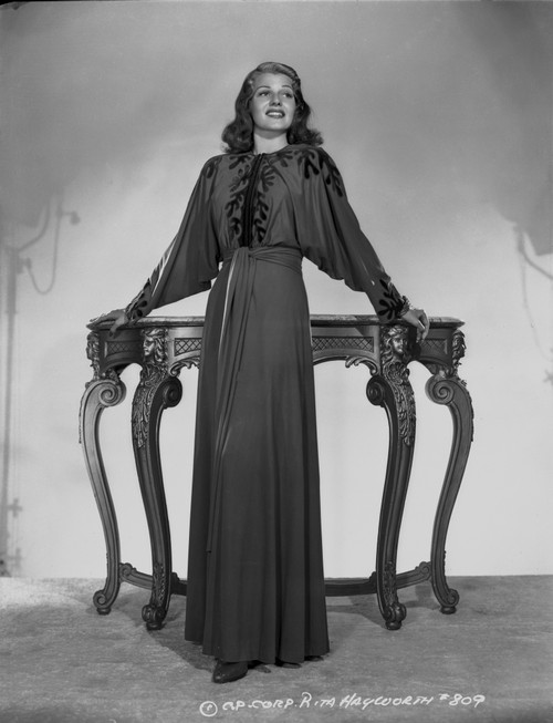 Rita Hayworth Leaning on Table in Black Gown Photo Print - Item # VARCEL698141