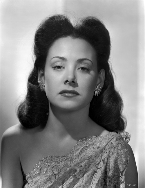 Carol Forman wearing an Embroidered Dress with Earrings Photo Print - Item # VARCEL698615