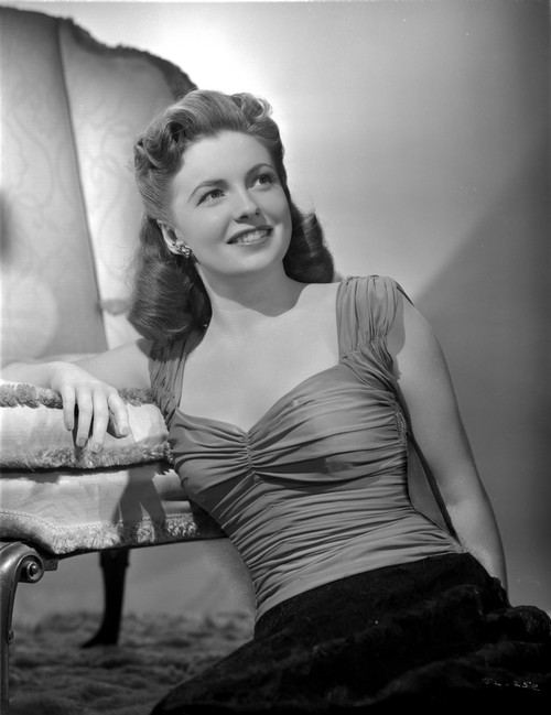 Joan Leslie on a Ruffled Top sitting on a Floor and smiling Photo Print - Item # VARCEL701385