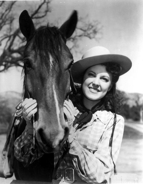Fay McKenzie smiling and posed with a Horse Photo Print - Item # VARCEL701666