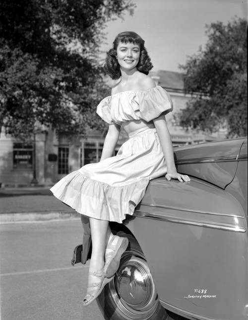 Dorothy Malone on a Ruffled Dress sitting on a Vintage Car Photo Print - Item # VARCEL701711